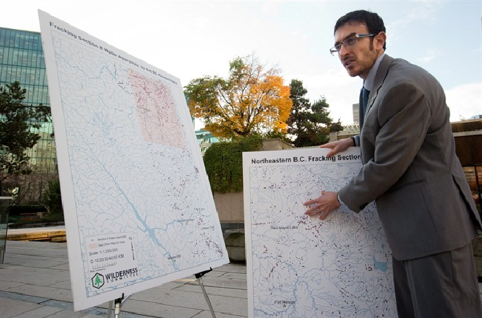 Eoin Madden, a climate campaigner with the Wilderness Committee, talks about sites indicated with dots on a map in northeastern B.C. where the provincial government has approved temporary water withdrawal for fracking. THE CANADIAN PRESS/Darryl Dyck.