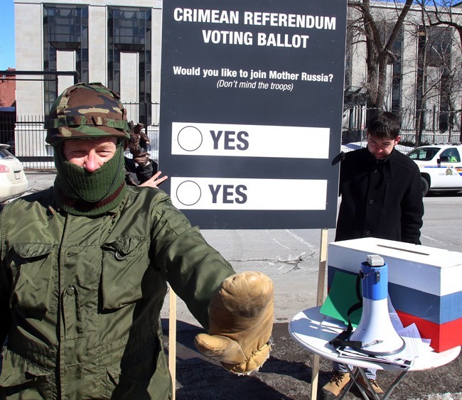 A protester disguised in military colours a takes part in a mock referendum to draw attention to the Crimean referendum Sunday March 16, 2014 outside the Russian Embassy in Ottawa on March 16, 2014.