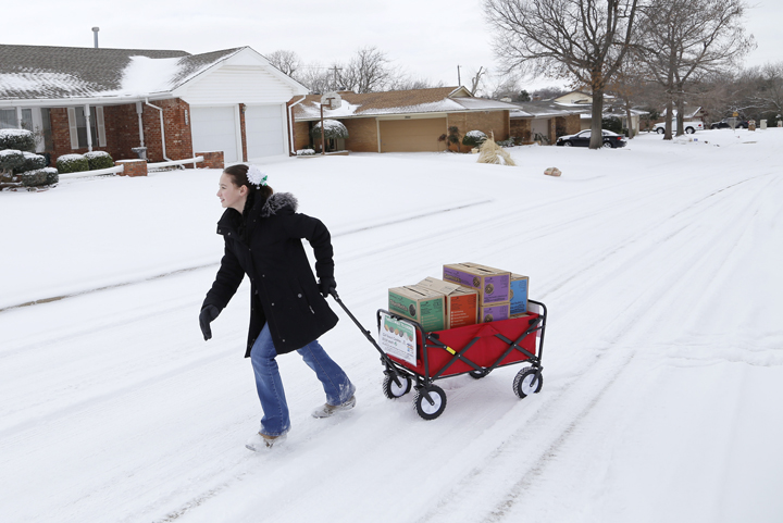  In this file photo from Feb. 6, 2014, Girl Scout Katie Francis pulls her wagon full of boxes of cookies in the snow through a neighbourhood in Warr Acres selling cookies in Oklahoma City.