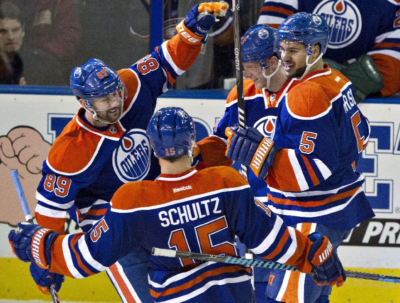 Edmonton Oilers' Sam Gagner (89), Nick Schultz (15), Ales Hemsky (83) and Mark Fraser (5) celebrate a goal against the Ottawa Senators during second period NHL hockey action in Edmonton, Alta., on Tuesday March 4, 2014. THE CANADIAN PRESS/Jason Franson.
