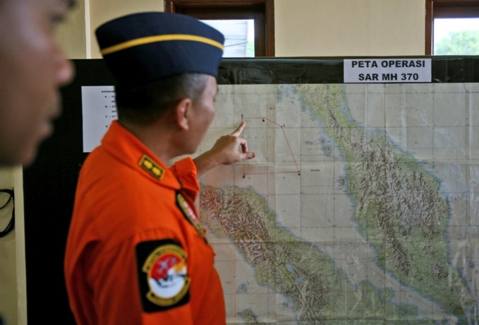 An Indonesia air force officer shows a map of Malacca Straits during a briefing prior to a search operation for the missing Malaysia Airlines Boeing 777, at Suwondo air base in Medan, North Sumatra, Indonesia, Tuesday, March 11, 2014. 