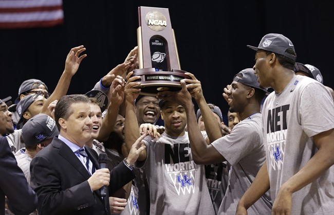 Kentucky's Aaron Harrison and his teammates hold up their trophy after an NCAA Midwest Regional final college basketball tournament game against Michigan Sunday, March 30, 2014, in Indianapolis.