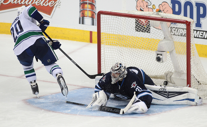 Chris Higgins of the Vancouver Canucks scores the game-winning goal against Ondrej Pavelec of the Winnipeg Jets in shootout action at the MTS Centre on Wednesday. 