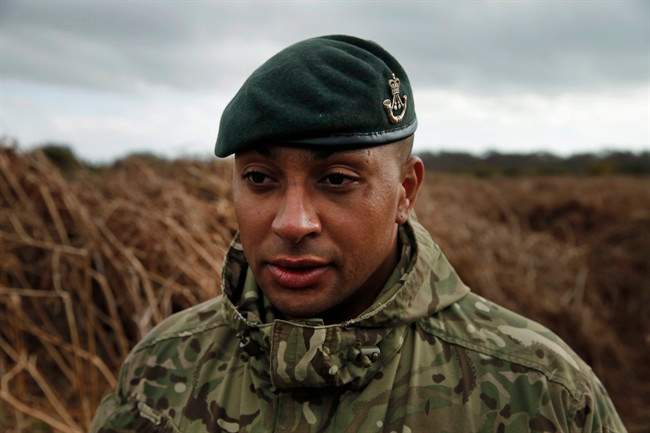 British army Lance Corporal Rob Walters walks on a WW1 practise trench as he poses for the photographers in Gosport, southern England, Thursday, March 6, 2014. 