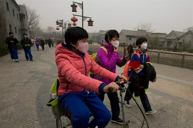 Children wearing masks walk home after school in Beijing, China on Feb. 25, 2013.