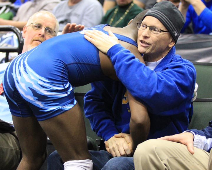 In this March 1, 2014 photo provided by Vanessa Schlueter, Minnesota wrestler Malik Stewart hugs Steve McKee moments after losing his Class 3A 120-pound high school wrestling title match to McKee's son, Mitchell, in St. Paul, Minn. Stewart's gesture to the terminally ill father of the opponent who had just beaten him captured the hearts of fans at Xcel Energy Center in St. Paul. 