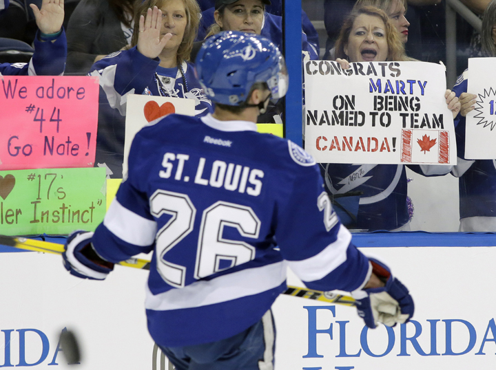 In this Feb. 6, 2014 file photo, a fan holds up a sign congratulating Tampa Bay Lightning right winger Martin St. Louis (26) for being selected to the Canadian Olympic hockey team before an NHL hockey game against the Toronto Maple Leafs, in Tampa, Fla. 