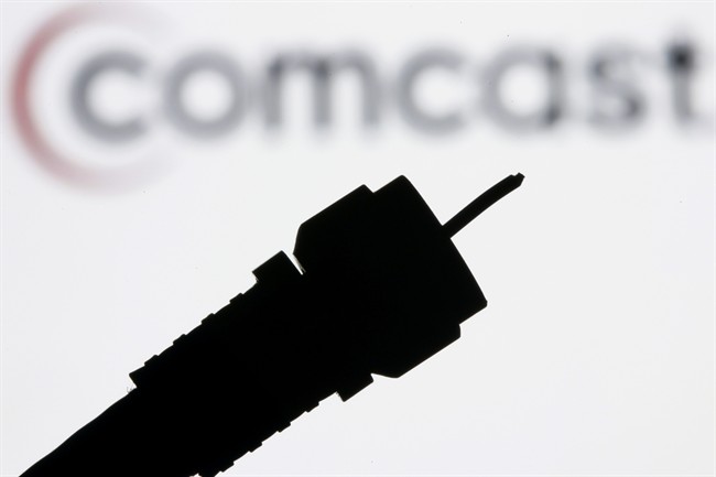 File photo: a silhouetted coaxial cable is photographed with the Comcast Corp. logo in the background.