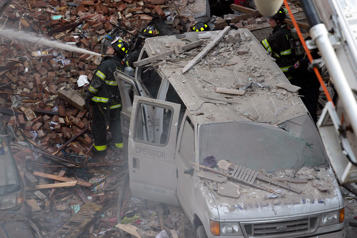Firefighters respond to a fire on 116th Street in Harlem after a building exploded in huge flames leading to the collapse of at least one building and several injuries, Wednesday, March 12, 2014, in New York.