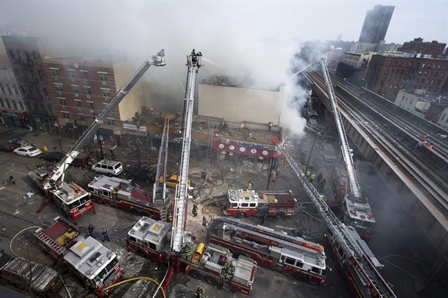 Firefighters battle a fire after a building collapses in the East Harlem neighborhood of New York, Wednesday, March 12, 2014.