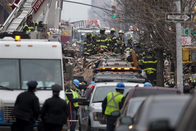 Firefighters respond to an explosion that leveled two apartment buildings in the East Harlem neighborhood of New York, Wednesday, March 12, 2014. (AP Photo/John Minchillo).