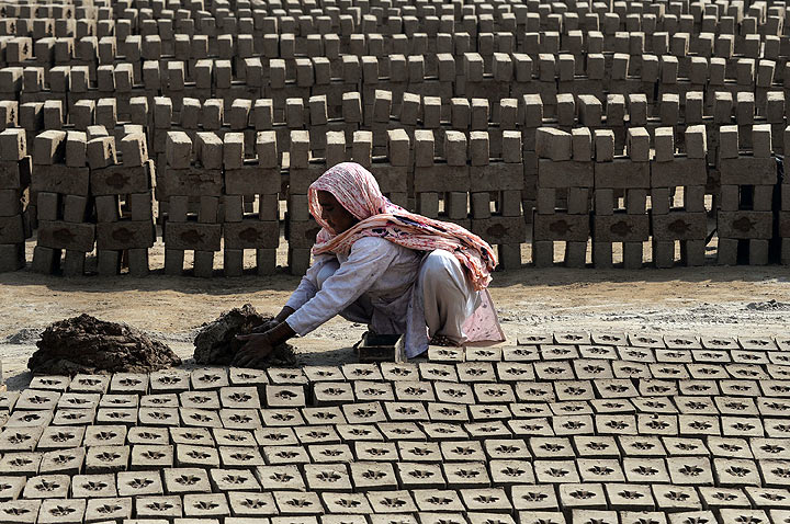 In this photograph taken on March 5, 2014, Pakistani female labourer Mukhtara Bibi makes bricks at a factory on the outskirts of Lahore, ahead of International Women's Day.