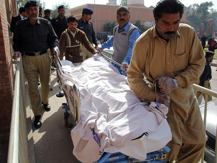 Pakistani paramedics and policemen move the body of a rape victim from a hospital in Multan on March 14, 2014. A Pakistani teenager died on March 14 after setting herself on fire after a court dropped charges against four men accused of raping her, police said. The incident occured in Muzaffargar district of Punjab province, where the horrific gang rape of an illiterate women in 2002 made headlines around the world.