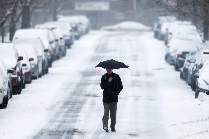A morning commuter walks to a train station during a winter snowstorm Monday, March 3, 2014, in Philadelphia. 