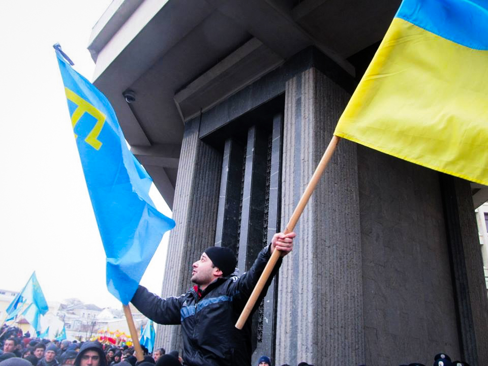 Activist holds Crimean Tatar and Ukrainian national flags (Simferopol, Crimea, Ukraine on February 26th, 2014)