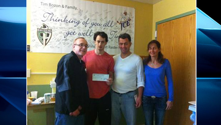Bruce Vance (left) presents a cheque to Tim Bozon and his parents at Royal University Hospital in Saskatoon on March 21, 2014.
