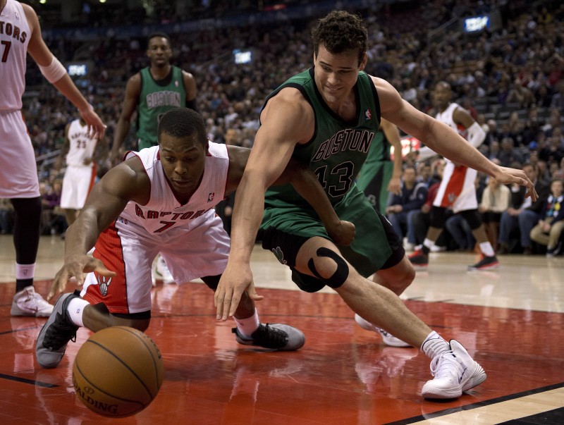 Toronto Raptors guard Kyle Lowry (left) and Boston Celtics forward Kris Humphries (right) dive for a loose ball during first half NBA action in Toronto on Friday March 28, 2014. THE CANADIAN PRESS/Frank Gunn.