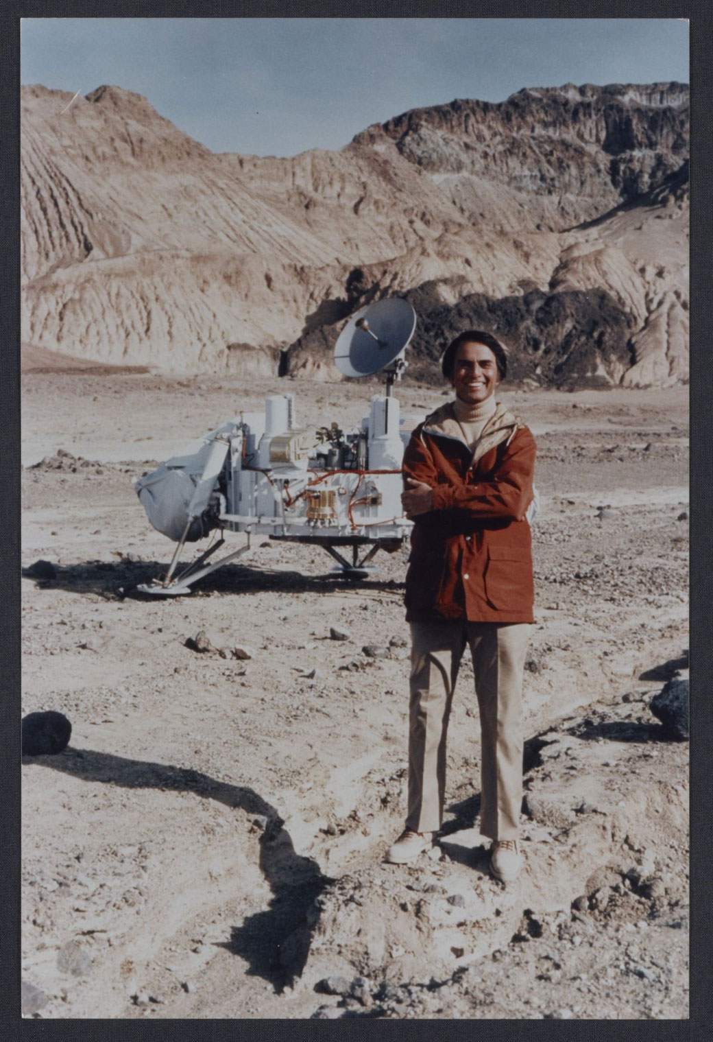 Carl Sagan standing next to a model of the Viking lander in Death Valley, California.