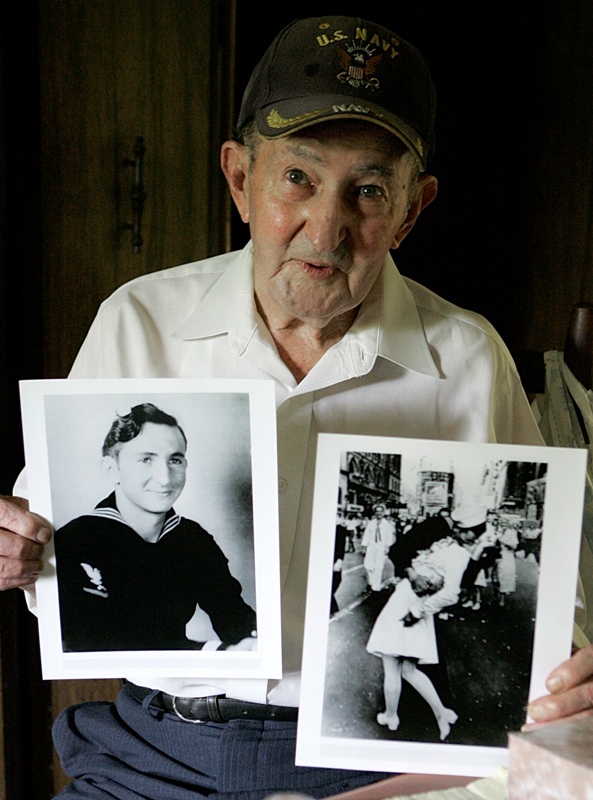  In this July 31, 2007 file photo, Glenn McDuffie holds a portrait of himself as a young man, left, and a copy of Alfred Eisenstaedt's iconic Life magazine shot of a sailor, who McDuffie claims is him, embracing a nurse in a white uniform in New York's Times Square, at his Houston home. McDuffie, who became known for claiming he was the sailor kissing a woman in Times Square in a famous World War II-era photo taken by a Life magazine photographer has died. (AP Photo/Pat Sullivan, File).