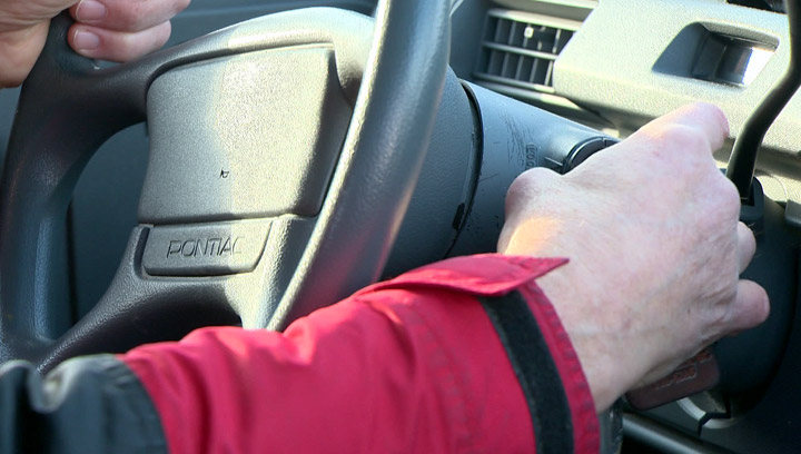 File: A close up photo of someone driving a vehicle.