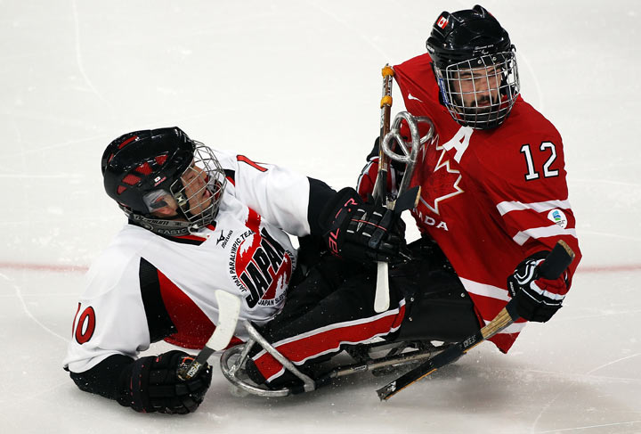 Takayuki Endo #10 of Japan collides with Greg Westlake #12 of Canada during the second period of the Ice Sledge Hockey Play-off Seminfinal Game on day seven of the 2010 Vancouver Winter Paralympic Games at UBC Thunderbird Arena on March 18, 2010 in Vancouver, Canada. 