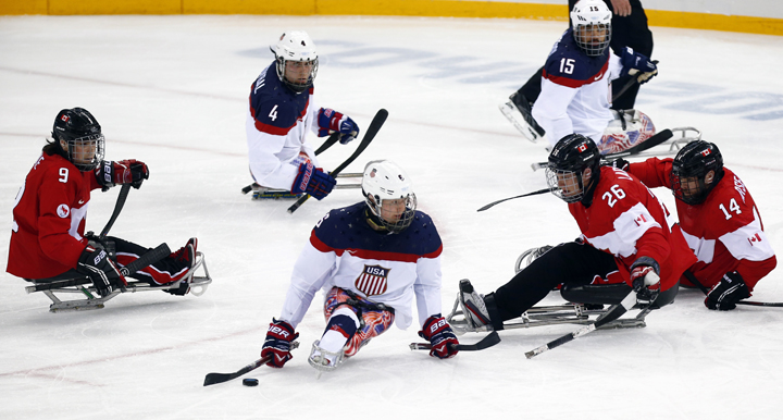 United States' Declan Farmer, center, Brody Roybal, top center, Nikko Landeros, top right, in action with Canada's Anthony Gale, left, Dominic Larocque, second from right, and Steve Arsenault, right, during the ice sledge hockey semifinal match between United States and Canada at the 2014 Winter Paralympics in Sochi, Russia, Thursday, March 13, 2014.