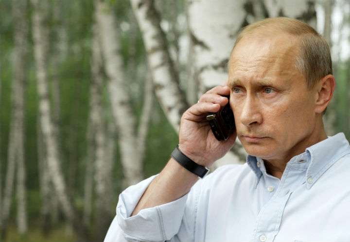 Russian Prime Minister Vladimir Putin speaks over the telephone with President Dmitry Medvedev while touring the region of fire damage near Nizhny Novgorod on July 30, 2010.