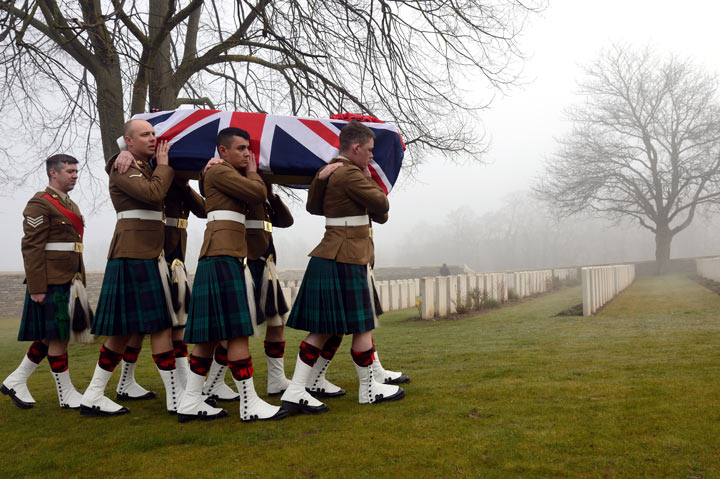 Soldiers carry the flag-draped casket of British soldier William McAleer, who died during World War I, is carried during his funeral at Loos British Cemetery in Loos-en-Gohelle, northern France, on March 14, 2014. 