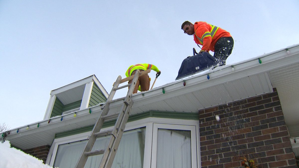 A Septagon Contracting crew clears a roof of snow.