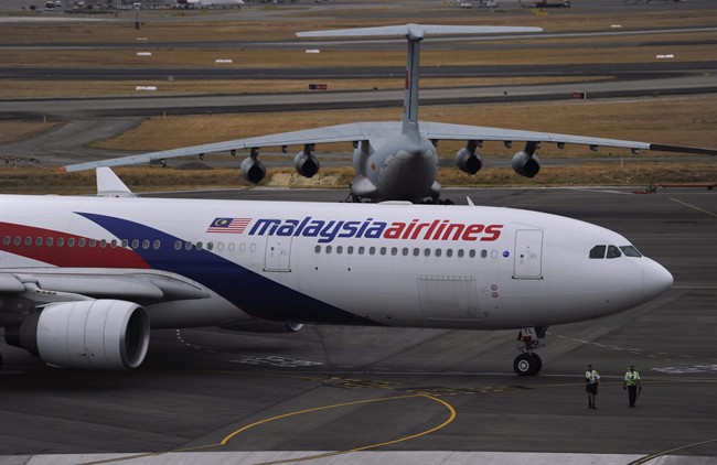 A Malaysia Airlines plane, foreground, prepares to go out onto the runway and passes by a stationary Chinese Ilyushin 76 aircraft at Perth International Airport in Perth, Australia, Tuesday, March 25, 2014. 