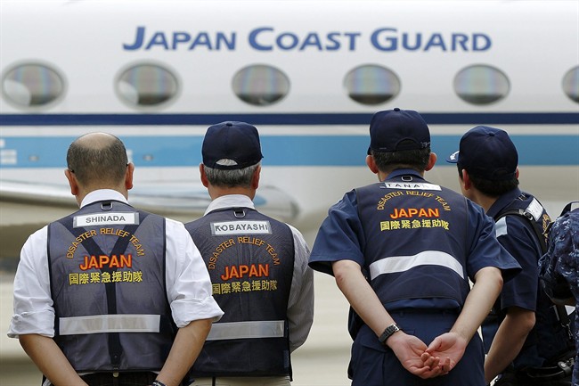 Members of the Japan Disaster Relief Team await the arrival of the Gulfstream 5 carrying members of the Japan Coast Guard at Pearce air force base on Wednesday, March 26, 2014, in Bullsbrook, Australia.