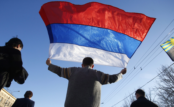 An activists carries a Russian flag during a rally at on March 23, 2014.