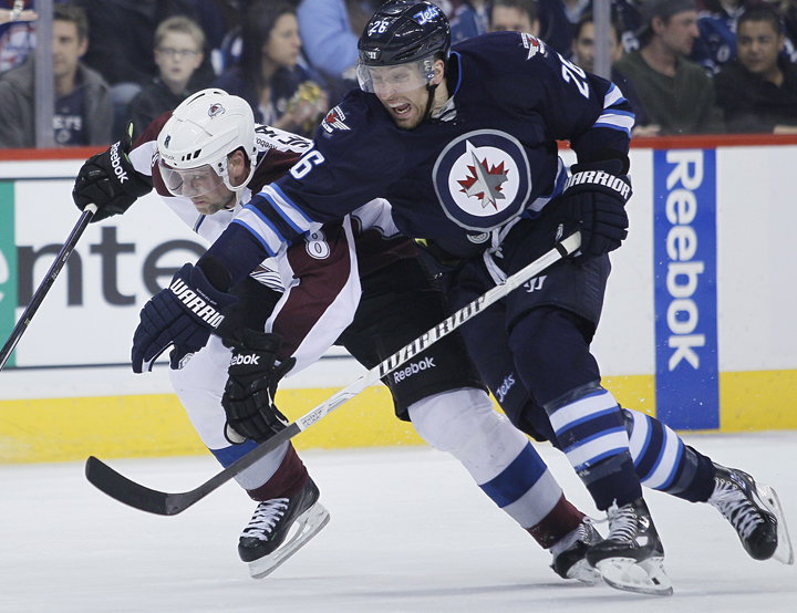 The Winnipeg Jets' Blake Wheeler (26) attempts to get around the Colorado Avalanche's Jan Hejda as they drive for the puck in Winnipeg on Wednesday.