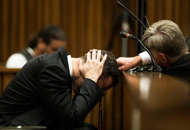 Oscar Pistorius, puts his hands to his head while listening to evidence from a witness speaking about the morning of the shooting of his girlfriend Reeva Steenkamp, in court on the fourth day of his trial at the high court in Pretoria, South Africa, Thursday, March 6, 2014.
