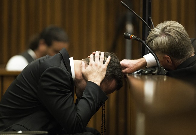 Oscar Pistorius, puts his hands to his head while listening to evidence from a witness speaking about the morning of the shooting of his girlfriend Reeva Steenkamp, in court on the fourth day of his trial at the high court in Pretoria, South Africa, Thursday, March 6, 2014.