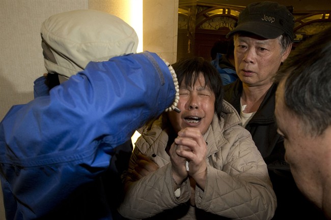 A relative of Chinese passengers aboard the Malaysia Airlines MH370, cries after being told the latest update in Beijing, China, Monday, March 24, 2014.