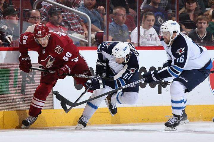 Michael Frolik (67) of the Winnipeg Jets battles for the puck with Antoine Vermette of the Phoenix Coyotes on Tuesday in Glendale, Ariz.
