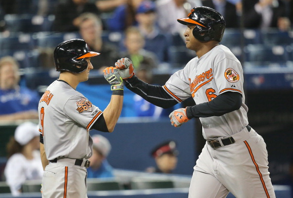 Jonathan Schoop #6 of the Baltimore Orioles is congratulated by David Lough #9 after hitting a solo home run in the fifth inning during MLB game action against the Toronto Blue Jays on April 24, 2014 at Rogers Centre in Toronto, Ontario, Canada. (Photo by Tom Szczerbowski/Getty Images).