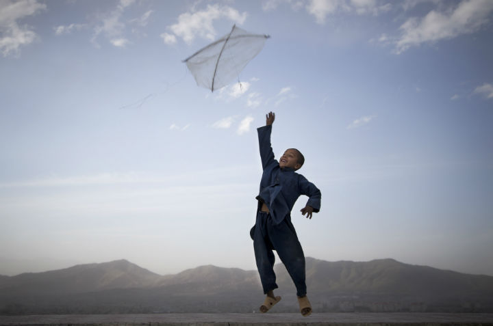 An Afghan boy flies his kite on a hill overlooking Kabul, Afghanistan on May 13, 2013.
