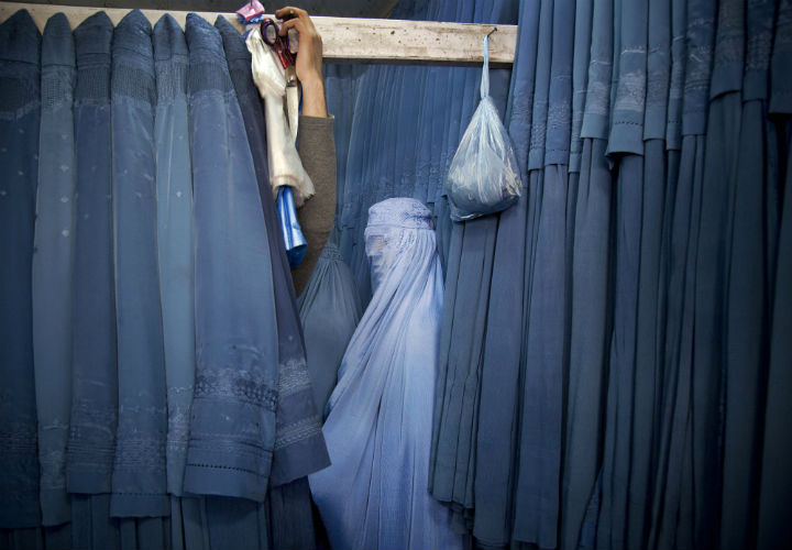 An Afghan woman waits in a changing room to try out a new Burqa, in a shop at in the old city of Kabul on Apr. 11, 2013.