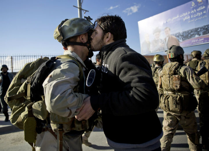 An Afghan special forces soldier, left, is kissed by an Afghan man after the commandos took over control of an election office after the Taliban launched an assault with a suicide bomber detonating his vehicle outside an election office in Kabul, Afghanistan, Tuesday, March 25, 2014.