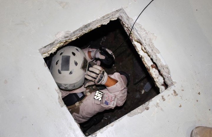 This image provided by the U.S. Immigration and Customs Enforcement (ICE) agency shows an agent examining one of two tunnels discovered April 1, 2014 in San Diego's Otay Mesa industrial park. The first tunnel, stretching about 600 yards, was discovered on Tuesday. Authorities say it was equipped with lighting, a crude rail system and wooden trusses. The other tunnel was discovered Thursday. It’s described as stretching more than 700 yards and more sophisticated, with an electric rail system and ventilation equipment. 