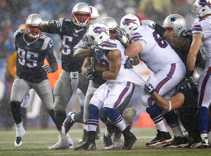 C.J. Spiller #28 of the Buffalo Bills is tackled by members of the New England Patriots in the second half during the game at Gillette Stadium on December 29, 2013