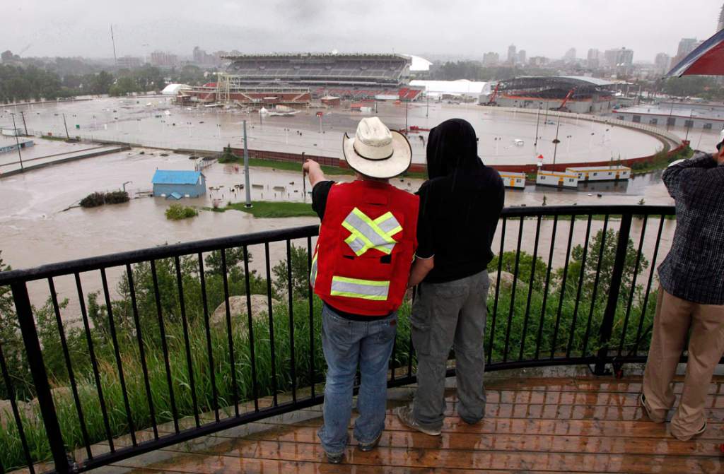 Calgarians look out over a flooded Calgary Stampede grounds and Saddledome in Calgary in June 2013.