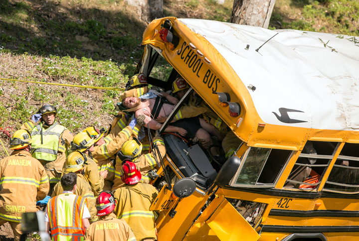 Firefighters extricate the driver from the front of a school bus that crashed, Thursday, April 24, 2014, in Anaheim, Calif. 