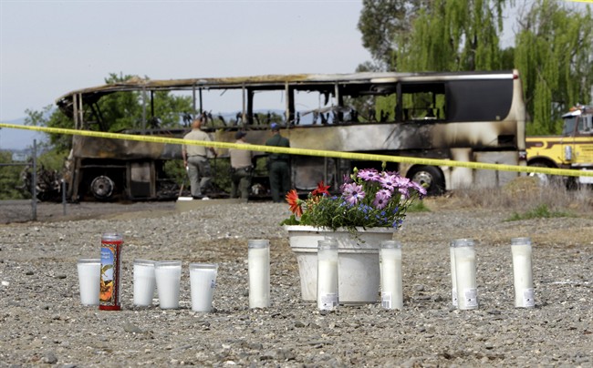 Candles and flowers are seen at a make-shift memorial, Friday, April 11, 2014, for the victims of a multi-vehicle accident that included a tour bus and a FedEX truck crashed on Interstate 5 in Orland, Calif. 