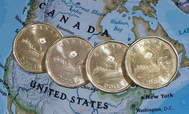 Canadian dollar coins, or Loonies, are displayed on a map of North America January 9, 2014 in Montreal.