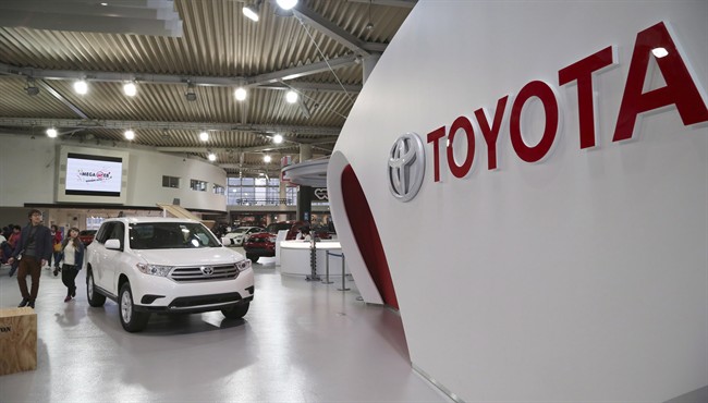 Visitors inspect cars on display at Toyota gallery in Tokyo Feb. 4, 2014.