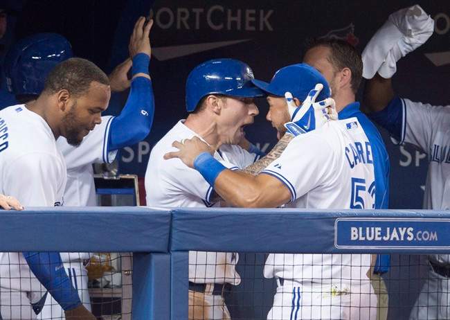 Toronto Blue Jays Brett Lawrie, centre, celebrates his three-run home run with teammate Melky Cabrera, right, during eighth inning MLB baseball action against the Baltimore Orioles in Toronto on Tuesday, April 22, 2014. THE CANADIAN PRESS/Darren Calabrese.