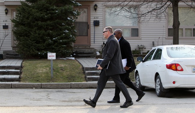 RCMP investigators walk past the house of Stephen Arthuro Solis-Reyes, 19, in London, Ont.
